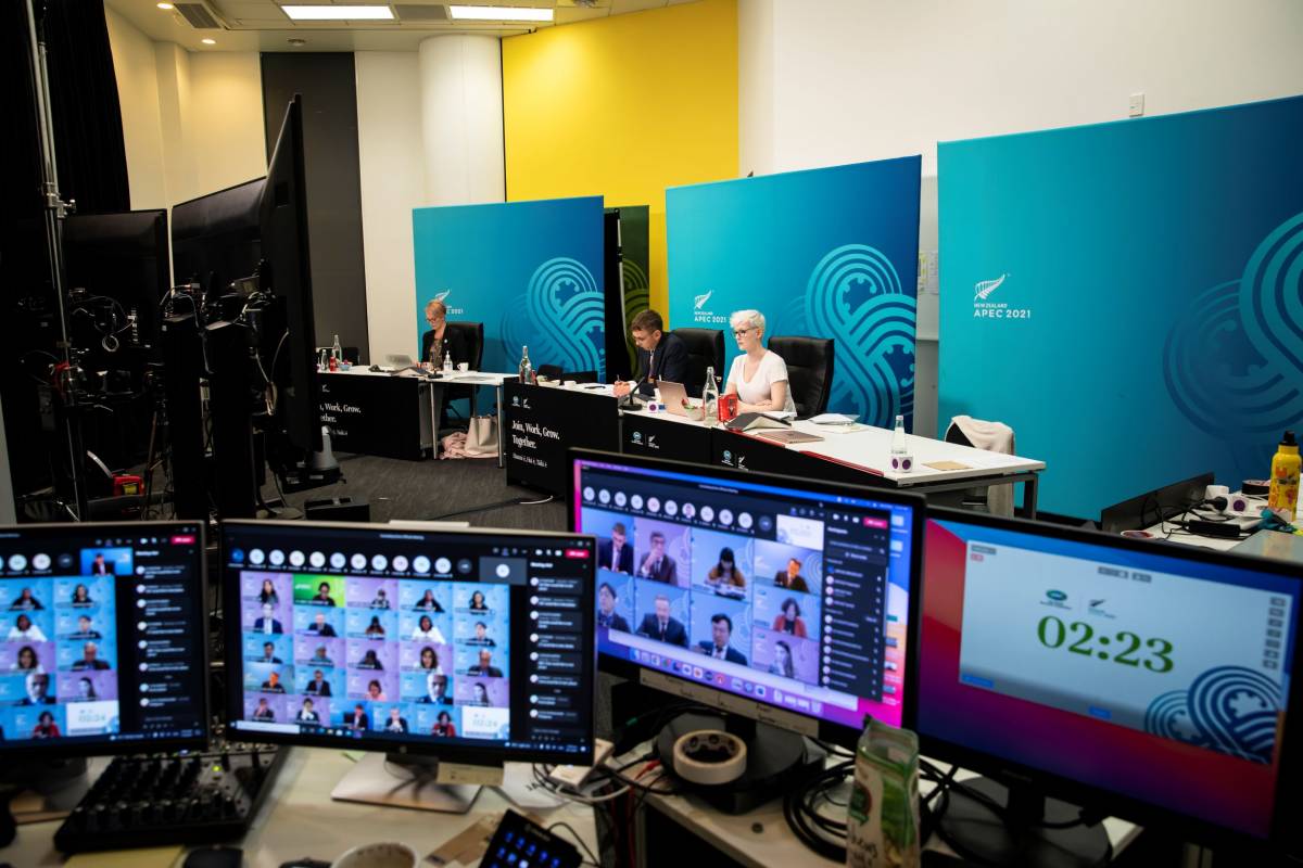 Behind the scenes of the APEC 2021 concluding senior officials meeting showing computer and media screens. 