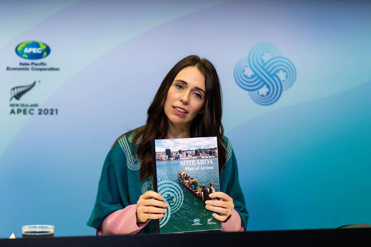 Prime Minister of New Zealand, Jacina Ardern holding a copy of the Aotearoa Plan of Action.