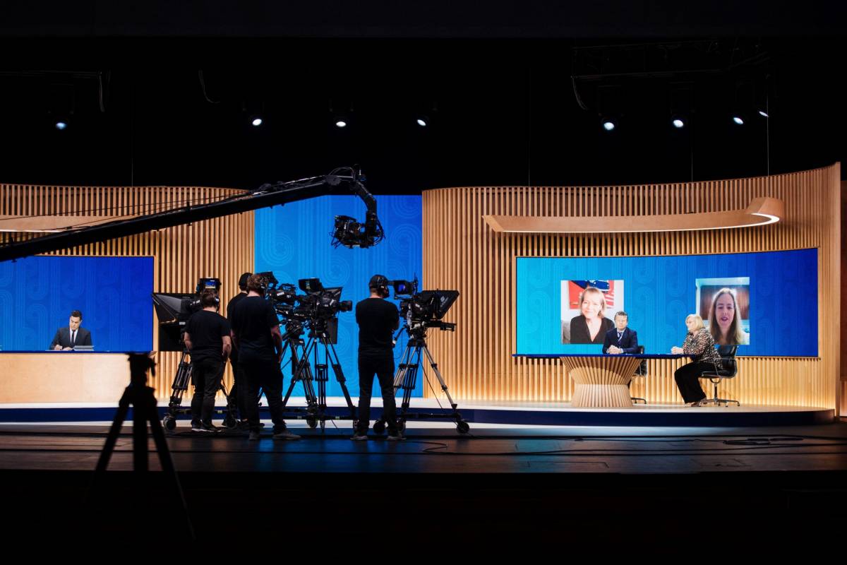 Wide shot of the APEC CEO Summit 2021 set including stage, desk and camera crew..