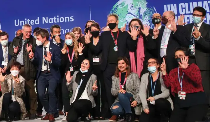 An image of NZ negotiators celebrating with others after agreement on the Glasgow Climate Pact was reached. . 