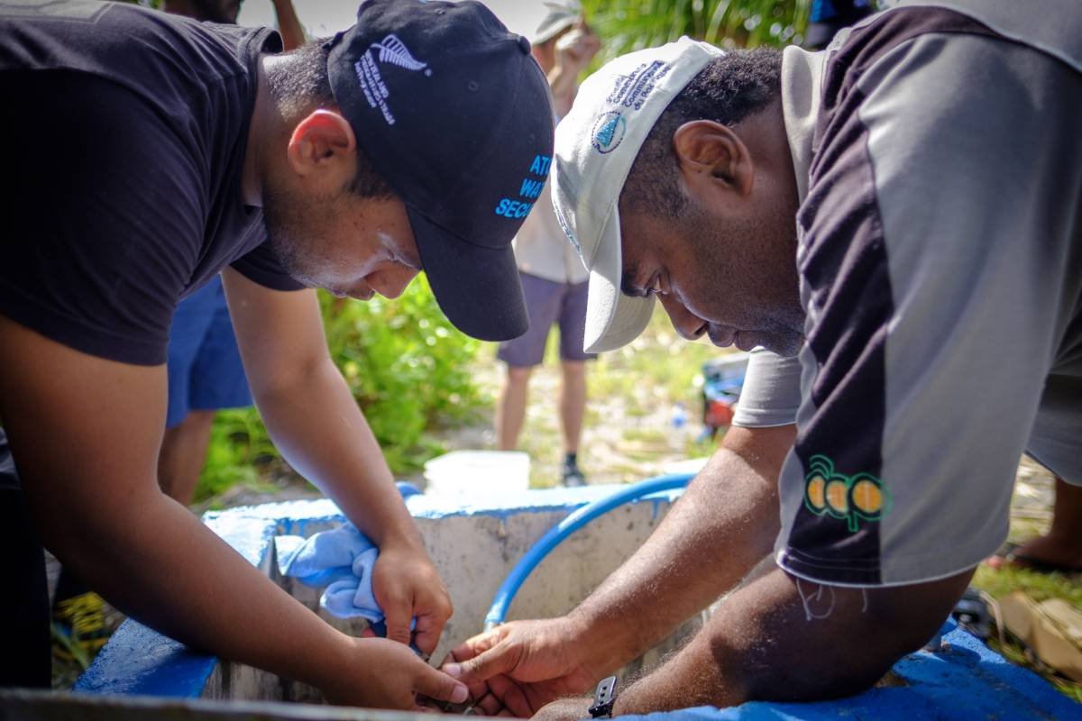 An image of men installing a water hose.