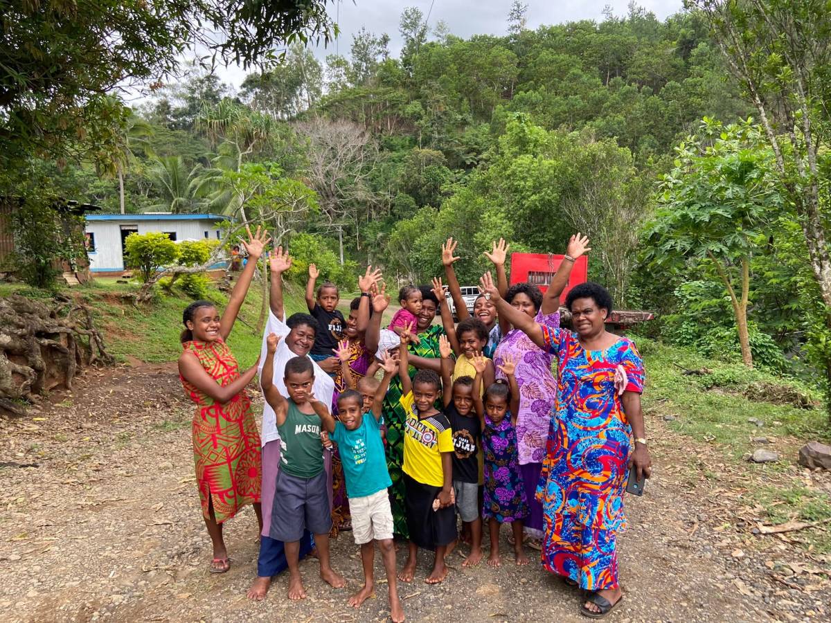 A group of people from the Vatawai community (Ba Province, Fiji) pose for a celebratory picture on the newly paved road.. 