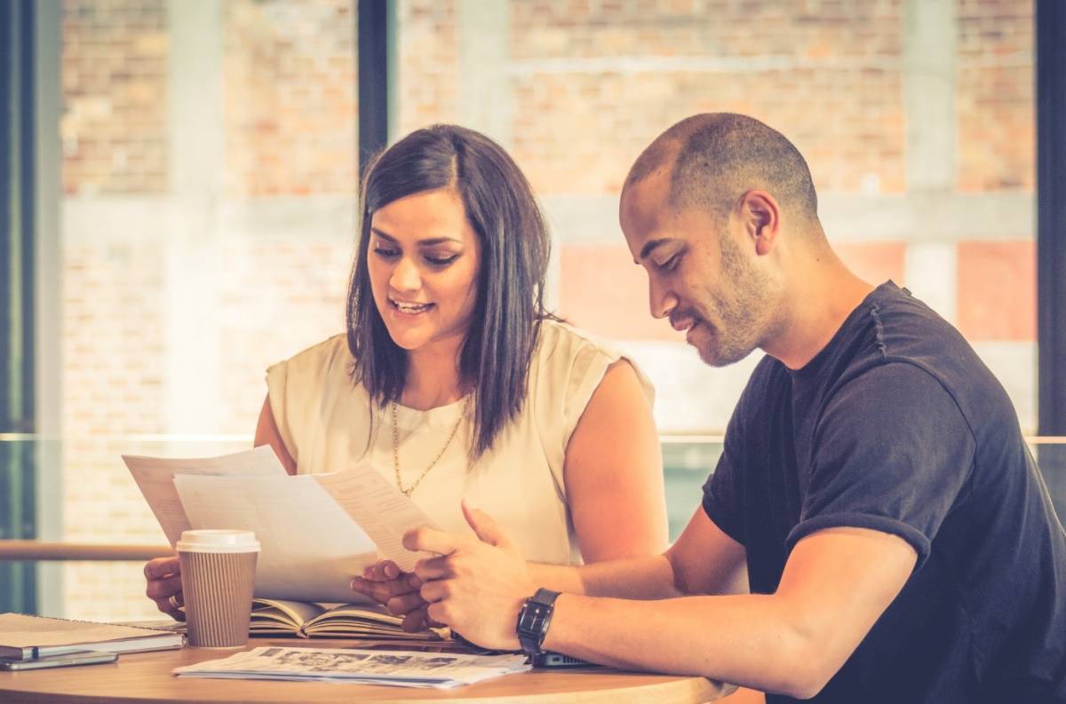 Māori woman and man read paperwork . 