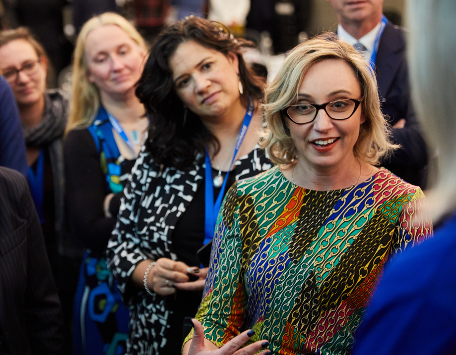 An image of four women in business, attending a conference. . 