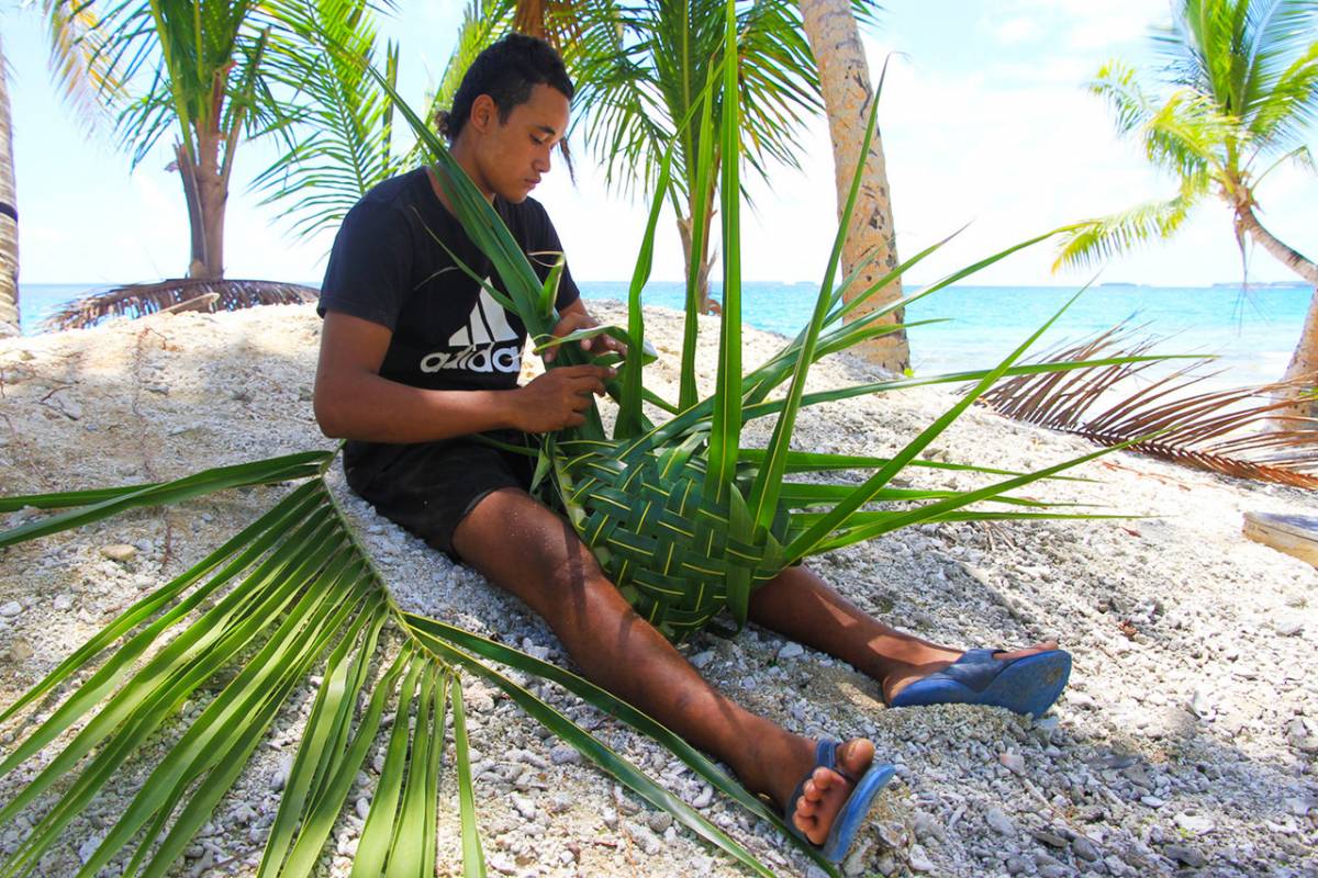 An image of a Tokelauan man weaving flax. 