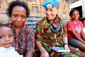 An image of an NZDF troop sitting with locals. . 